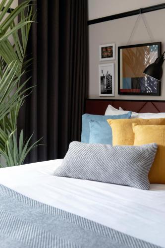 a bed with white sheets and yellow pillows in a bedroom at The Mont in Dublin