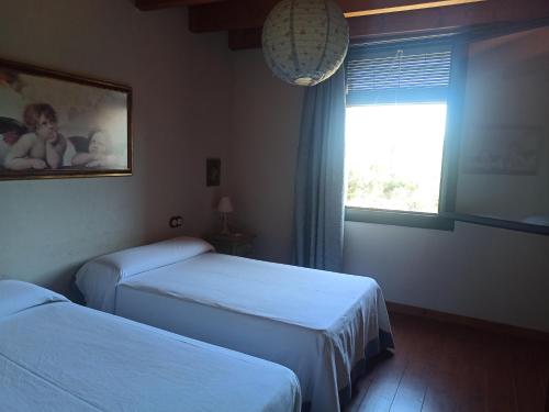 a hotel room with two beds and a window at El Molí de Cal Pastisser in Avellanes