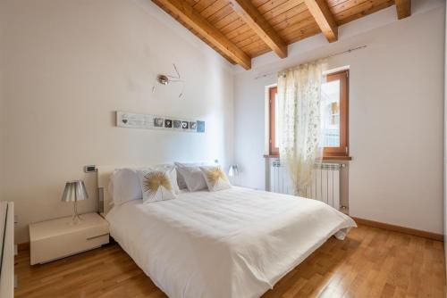 um quarto branco com uma cama grande e uma janela em Casa Francesca Relax em Limone sul Garda