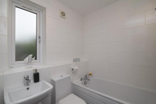 Baño blanco con aseo y lavamanos en The Kelvin - Peaceful West End River View Property, en Glasgow