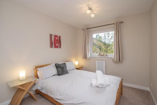 Un dormitorio con una cama blanca y una ventana. en The Kelvin - Peaceful West End River View Property, en Glasgow
