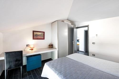 Habitación blanca con cama y escritorio en Colonno Penthouse, en Colonno