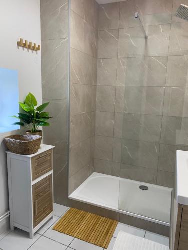 La salle de bains est pourvue d'une douche et d'une baignoire. dans l'établissement Beure maison chaleureuse et cosy, à Beure