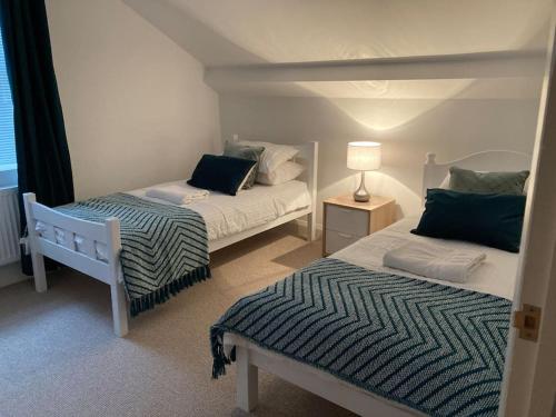um quarto com duas camas e um candeeiro em Marni’s Cottage - Rural location & fell views em Frizington