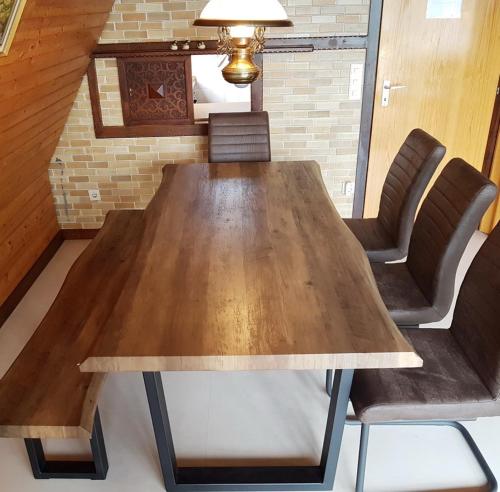 a wooden table in a room with chairs and a ceiling at Waldsee in Nagel