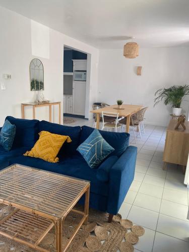 un salon avec un canapé bleu et une table dans l'établissement Beure maison chaleureuse et cosy, à Beure