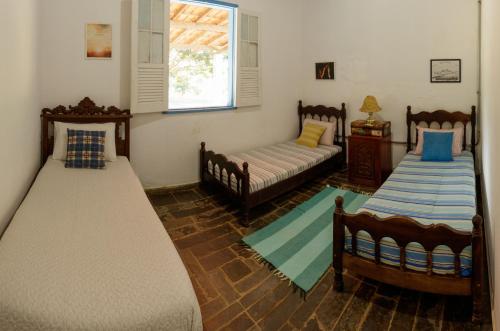 Habitación con 2 camas y ventana en Fazenda Com Piscina e Churrasqueira Curvelo, en Curvelo