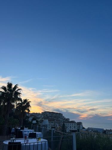 a view of a city at sunset with a palm tree at Albergo Villa Vittoria in Rodi Garganico