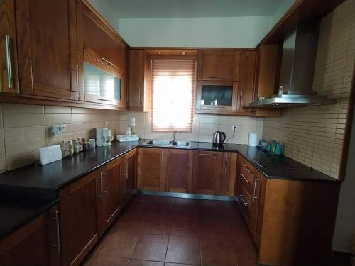 a kitchen with wooden cabinets and black counter tops at Borgo Majoca - Μονοκατοικία σε κυκλαδίτικο νησί in Mési