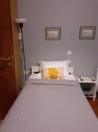 a bedroom with a white bed with yellow pillows at Borgo Majoca - Μονοκατοικία σε κυκλαδίτικο νησί in Mési