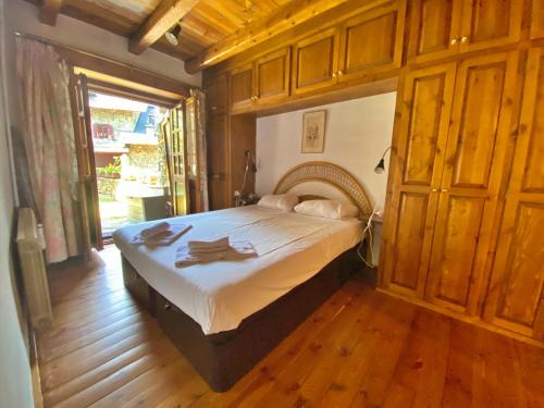Pleta de Ordino 55 Casa Rústica hasta 6 personas في أوردينو: غرفة نوم بسرير في غرفة ذات أرضيات خشبية
