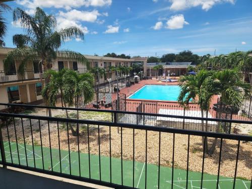 a view of the pool at a resort with palm trees at Super 8 by Wyndham St. Petersburg in St Petersburg