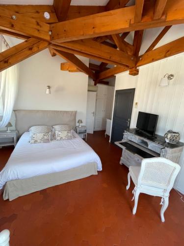 1 dormitorio con cama blanca y piano en Manoir d'Amaury - Chambres d'hôtes, en Gréoux-les-Bains