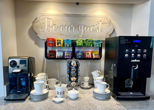 un piano di lavoro con tazze, macchinetta del caffè e macchinetta del caffè di Harbour House a Weymouth