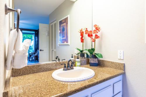 a bathroom with a sink and a mirror at Country Club Villas 124 in Kailua-Kona