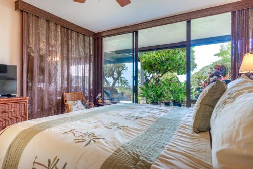 um quarto com uma cama grande e uma janela grande em Country Club Villas 124 em Kailua-Kona