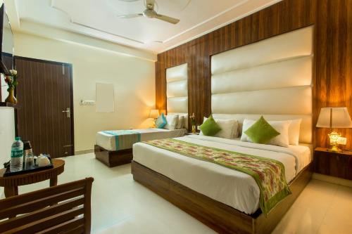 a hotel room with two beds and a table and a bed at Hotel Earth in New Delhi