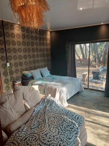 a bedroom with two beds and a couch and a window at Vulture's View 8 in Hartbeespoort