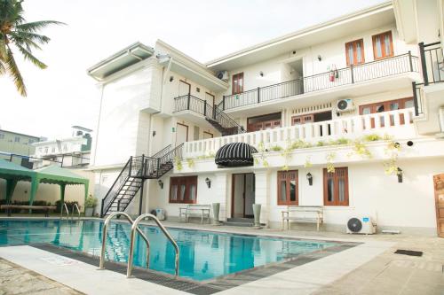 a hotel with a swimming pool in front of a building at Forever City Hotel in Kiribathgoda