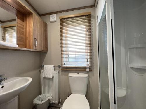 a small bathroom with a toilet and a sink at Stewarts Resort Lodge 54 in St Andrews