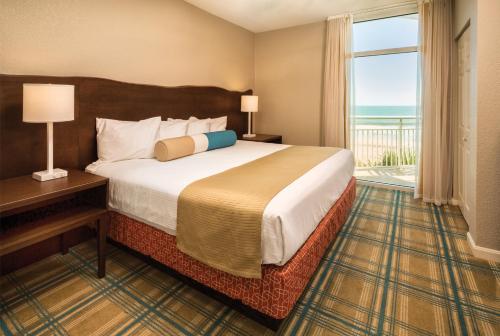 a hotel room with a bed and a large window at Club Wyndham Ocean Boulevard in Myrtle Beach