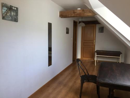 a dining room with a table and a piano at KERFERNAND in Berné