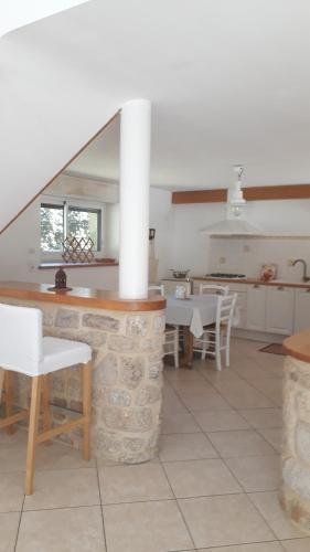 a kitchen and dining room with white tables and chairs at KERFERNAND in Berné