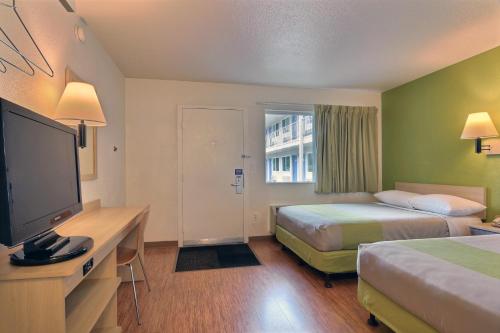a hotel room with two beds and a flat screen tv at Motel 6-Tumwater, WA - Olympia in Tumwater