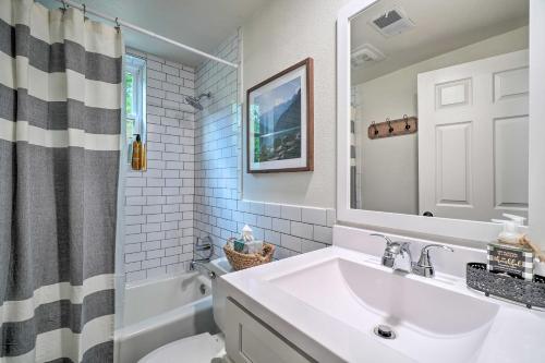 ein Badezimmer mit einem Waschbecken, einem WC und einem Spiegel in der Unterkunft Updated Knoxville Home with Media Room and Patio! in Knoxville