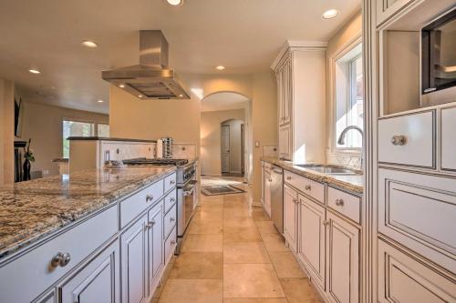 a large kitchen with white cabinets and granite counter tops at Moses Lake Retreat with Salt Water Hot Tub! in Moses Lake