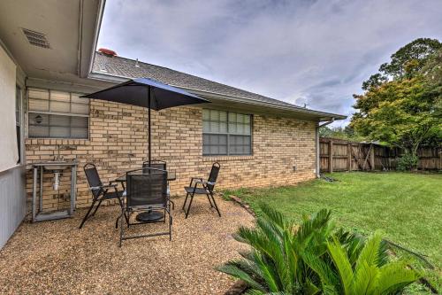 a patio with a table and chairs and an umbrella at Welcoming Hattiesburg Home Less Than 2 Mi to USM! in Hattiesburg