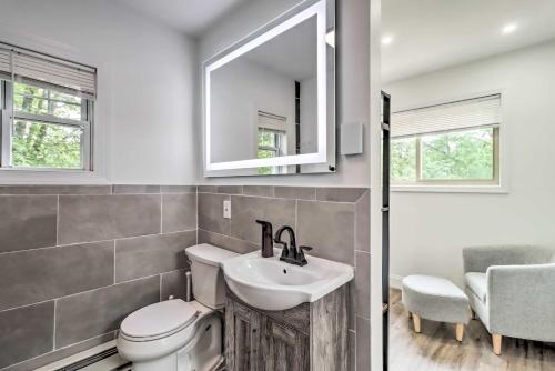 ein Badezimmer mit Waschbecken, Toilette und Spiegel in der Unterkunft Chic Long Pond Family Home with Fire Pits and Deck! in Long Pond