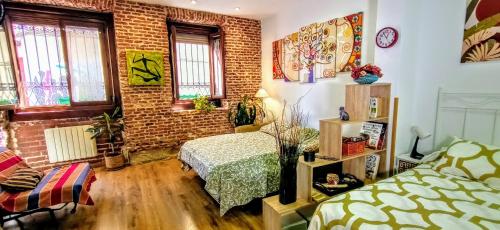 - une chambre avec un lit et un mur en briques dans l'établissement Apartamento Lavapies al lado del Rastro, à Madrid