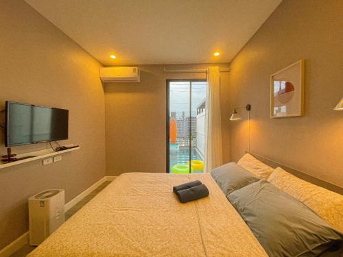 a bedroom with a large bed with a flat screen tv at Sunny Afternoon Pool Villa ~ Hua-Hin in Hua Hin