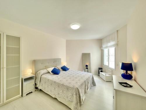 a bedroom with a bed with blue pillows at Marbella del Mar II Beachfront- EaW Homes in Marbella
