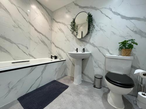 een badkamer met een toilet, een wastafel en een bad bij The Haven in Greenock