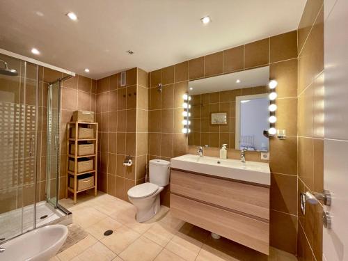 a bathroom with a toilet and a sink and a mirror at Marbella del Mar II Beachfront- EaW Homes in Marbella