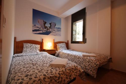a bedroom with two beds and a window at Ransol 3.6 Apartamento 1 km pistas Tarter in Canillo