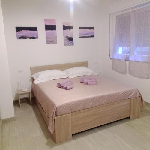 a bedroom with a bed with two pink towels on it at Appartamento ROSA - Colori del Lago d'Orta - NUOVA STRUTTURA A OMEGNA in Omegna