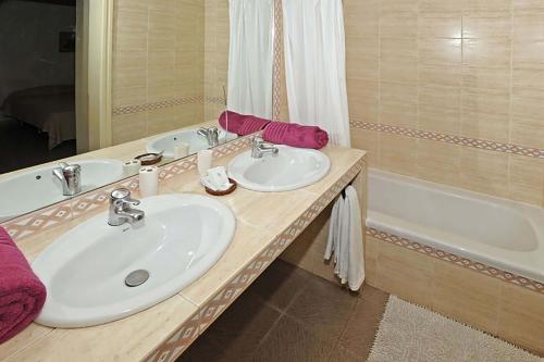 ein Badezimmer mit 2 Waschbecken und einer Badewanne in der Unterkunft Chalet Maria in Maspalomas