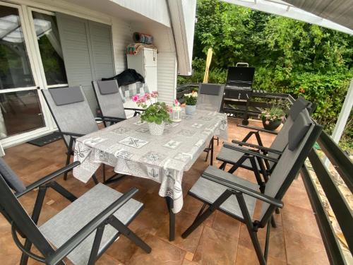 una mesa de comedor y sillas en un patio con un perro en Icuka vendèghàza, en Kiskunlacháza