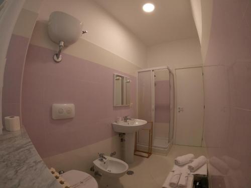 a bathroom with a sink and a toilet and a mirror at Ostello Villafranca in Pignola