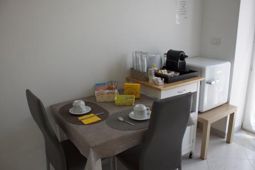 a dining room table with chairs and a coffee machine at Ostello Villafranca in Pignola