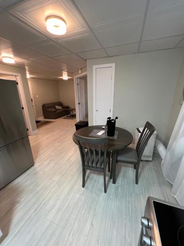 a room with a table and chairs and a living room at Le Centre-Ville in Rouyn