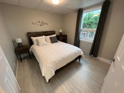 a bedroom with a large bed and a window at Le Centre-Ville in Rouyn-Noranda
