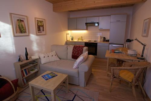 a living room with a couch and a kitchen at Apartment Amberg in Ötztal-Bahnhof