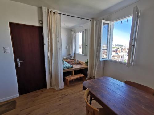 un salon avec une table et une grande fenêtre dans l'établissement le 5e ciel : un nid au dessus de Marseille, à Marseille