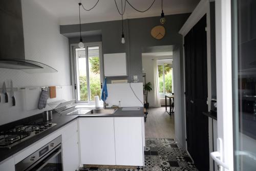 a kitchen with a sink and a stove top oven at Nouveau : maison à 50 m de la plage in Larmor-Plage