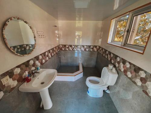 a bathroom with a sink and a toilet and a tub at Matua guest house in Jvari