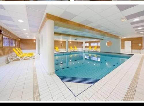 duży basen w dużym budynku w obiekcie T2 Les orres 1800 : pied des pistes avec piscine w mieście Les Orres